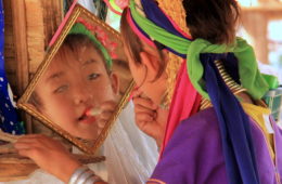 A little girl from the thai hill tribes applying make-up